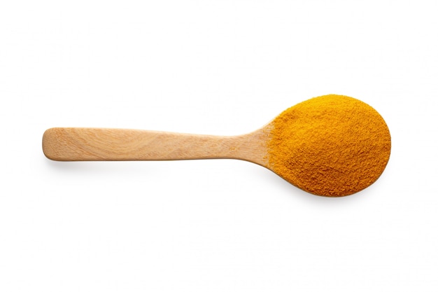 Yellow turmeric powder in a wooden spoon isolated on white