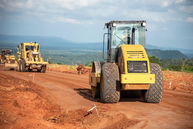 Photo yellow vibratory soil compactor working on highway construction site