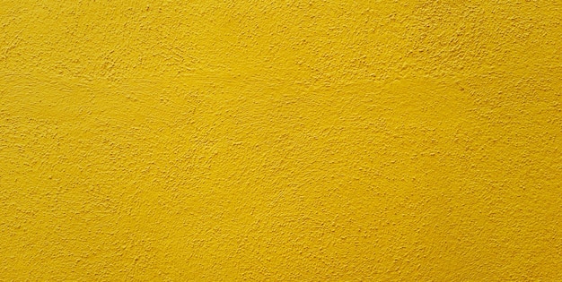 A yellow wall with a rough textured surface.