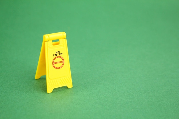 A yellow wet floor sign with a no entry sign on it.