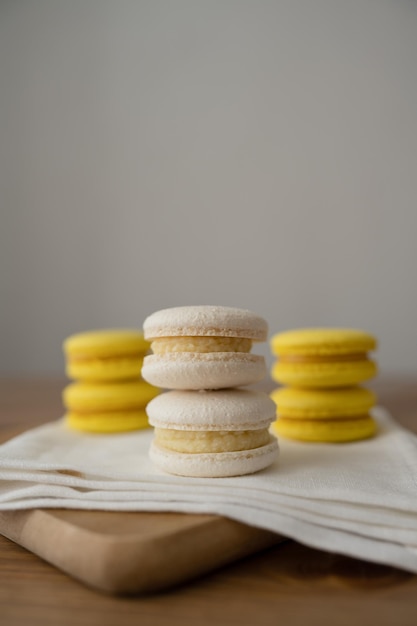 Photo yellow and white macarons on a wooden table