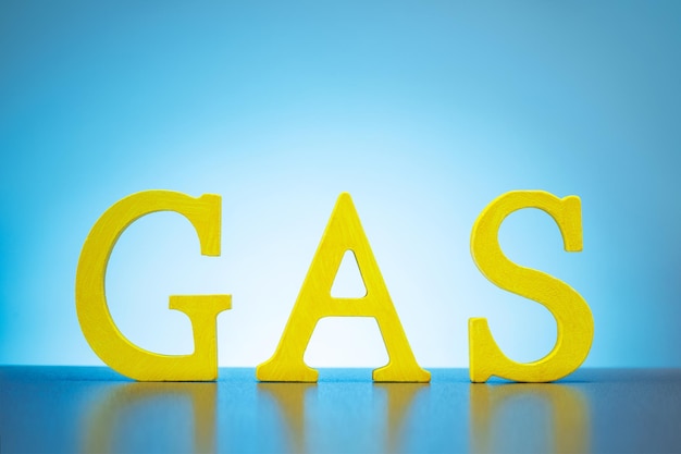 Yellow wooden letters forming the word Gas on blue background Concept of gas embargo crisis and sanctions