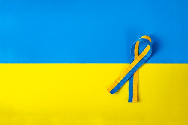 Yellowblue colors of the Ukrainian flag symbolic ribbon of solidarity isolated lies on a yellowblue background