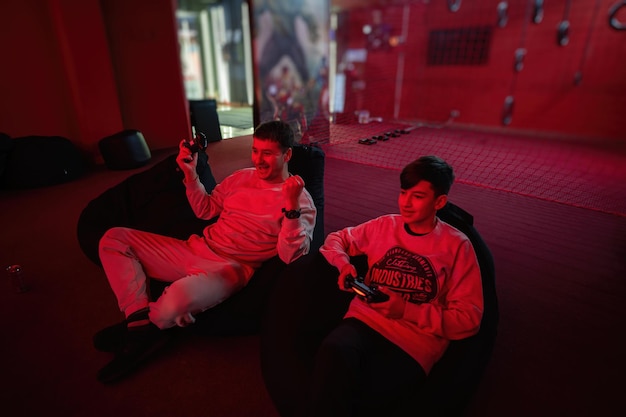 Yes i am winner Father and son play gamepad video game console in red gaming room Dad and kid gamers