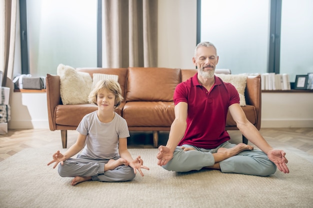 Yoga. Good-looking fit man doing yoga with his son