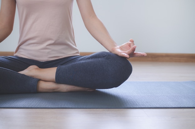 Yoga and meditation lifestyles. close up view of young beautiful woman practicing yoga namaste pose in the living room at home.