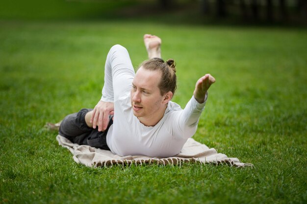 Yoga in morning park - instructor is training for flexibility, telephoto