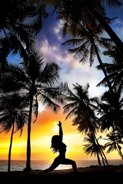 Yoga silhouette near palm trees