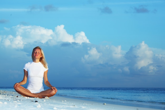 Yoga woman on sea coast