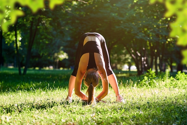 Yoga Young woman practicing yoga or dancing or stretching in nature at park Health lifestyle concept