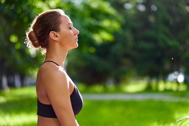 Yoga. Young woman practicing yoga meditation and relax in nature at the park. Health lifestyle concept