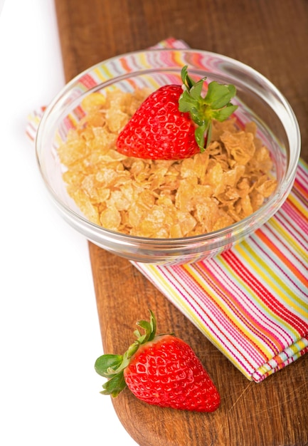 Yogurt bowl with fresh sliced strawberries and dry corn flakes Traditional corn flakes breakfast concept Healthy eating concept Food and health