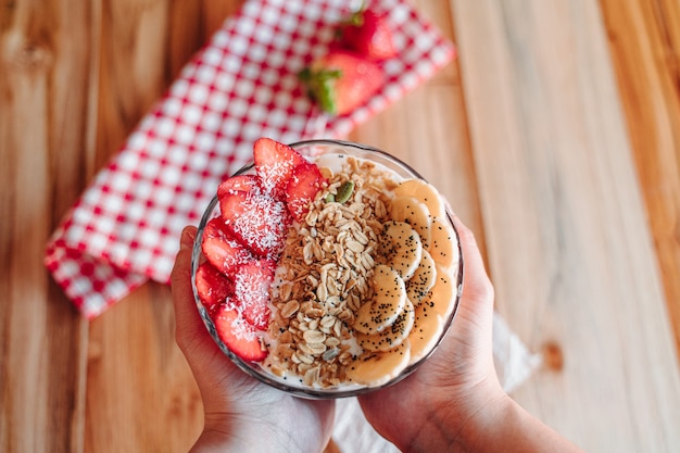 Yogurt bowl with fruits such as strawberry and banana, chia, dried fruits and crunchy muesli.