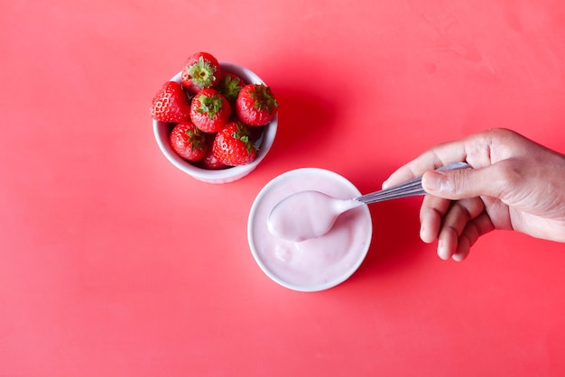 Yogurt and strawberry in a bowl on white