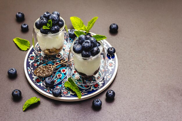 Yogurt with blueberries and chia seeds on cutting board