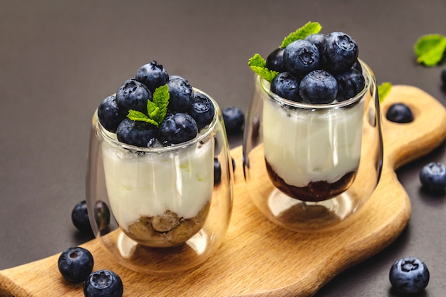 Yogurt with blueberries and chia seeds on cutting board