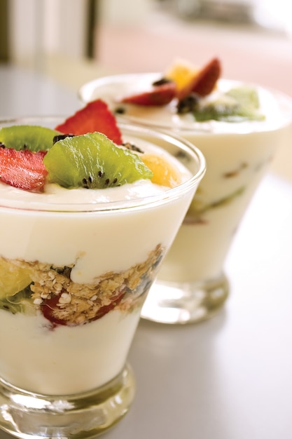 yogurt with fruits and cereal in glass container