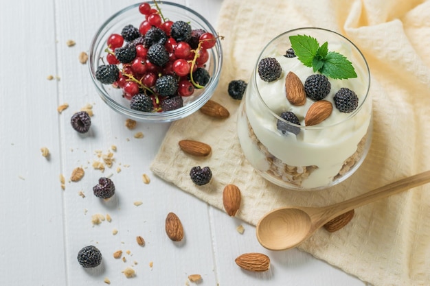 Yogurt with granola and blackberries in a glass Cup on a cloth