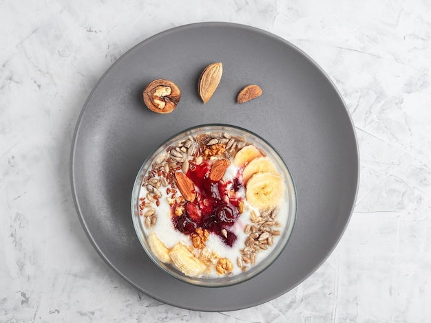 Yogurt with granola, nuts and cherry jam in a bowl