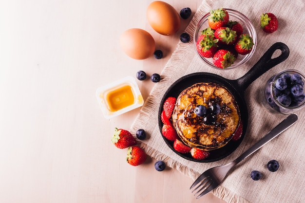 Yop view of Stack of homemade pancakes with blueberries and strawberries, perfect for breakfast