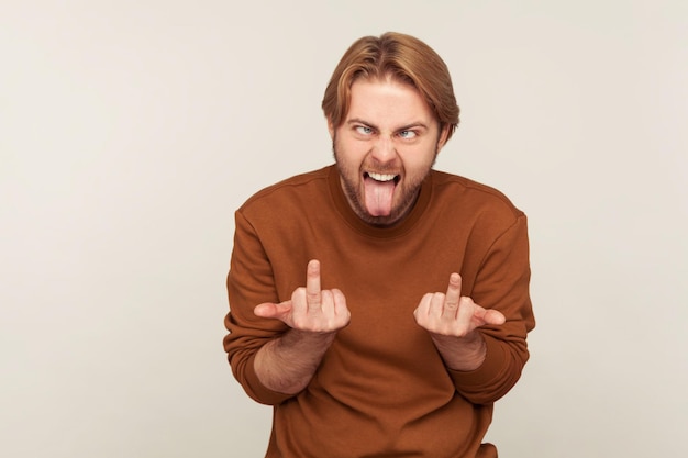 You back off. Portrait of mad crazy bearded man looking with insane expression, showing middle finger