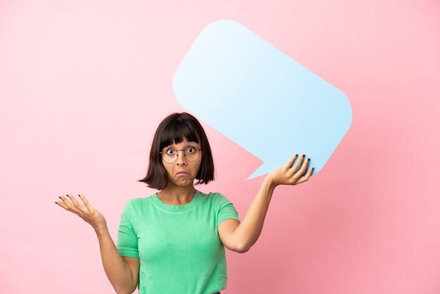 Youing woman holding an empty speech bubble and having doubts