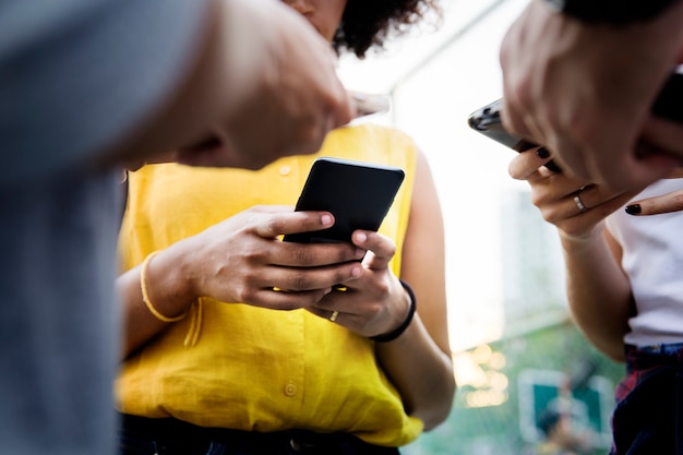 Young adult friends using smartphones outdoors