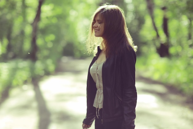 Young adult girl on a walk in the park jacket clothes