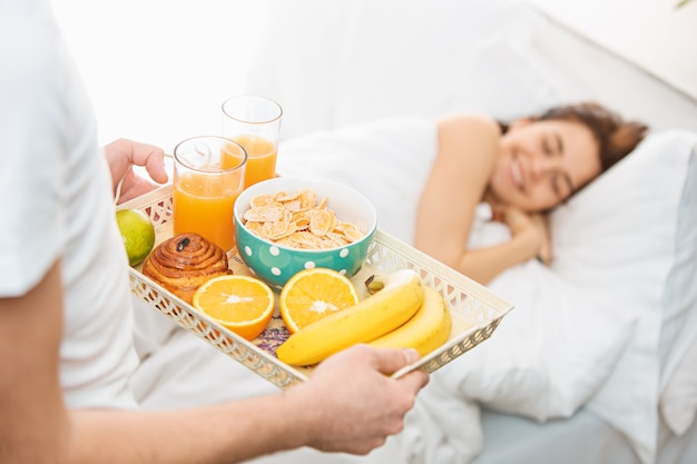 Young adult heterosexual couple lying on bed in bedroom