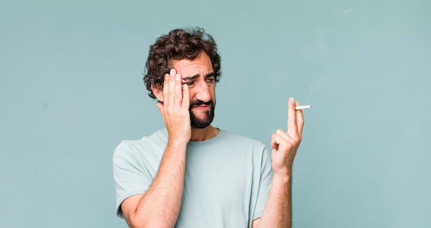 Photo young adult hispanic crazy man with a cigarette