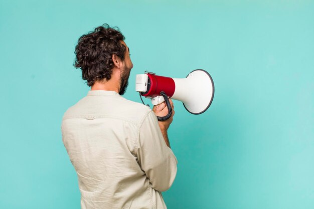 Young adult hispanic crazy man with a megaphone