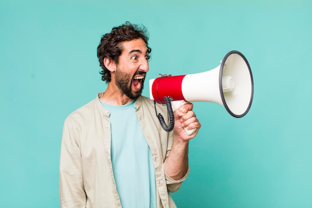 Young adult hispanic crazy man with a megaphone