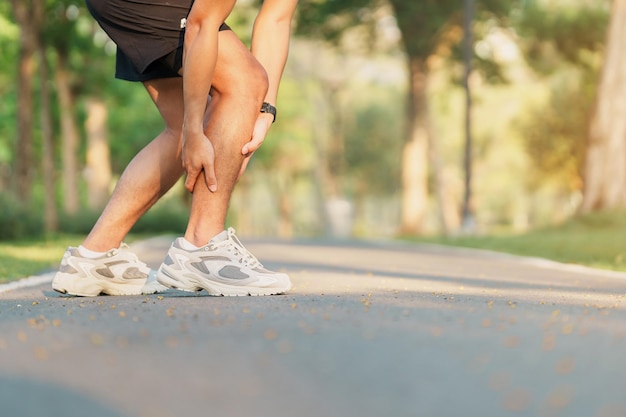 Young adult man with his muscle pain during running runner man having leg ache due to Calf muscle pull Sports injuries and medical concept