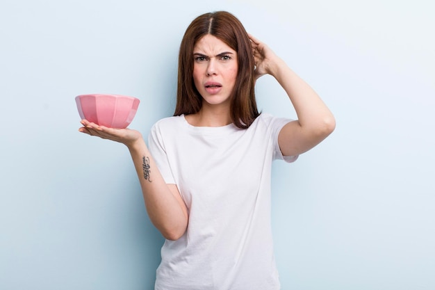 Young adult pretty woman holding an empty bowl