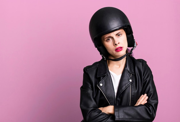 Young adult pretty woman motorbike rider with leather jacket and helmet