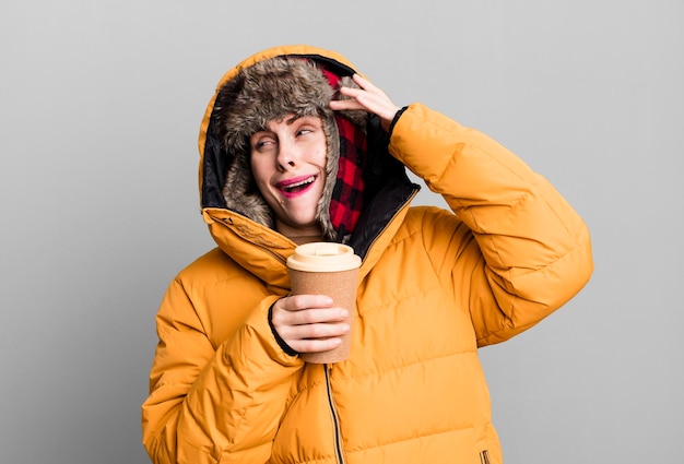 Photo young adult pretty woman wearing anorak and winter hat and holding a take away coffee