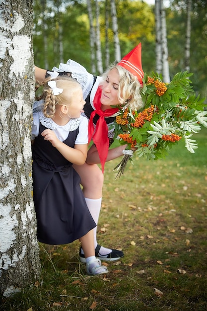 Photo young and adult schoolgirl on september mother and daughter having fun together generations of