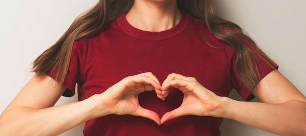 Young adult smiling woman portrait show heart with her hands