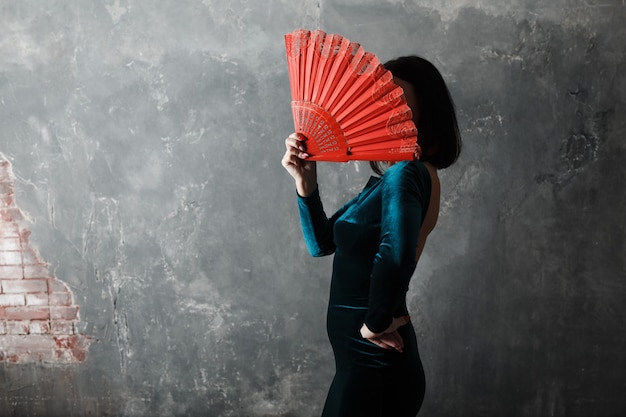 Young adult spanish woman dancing flamenco on gray vintage background