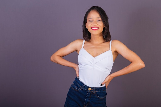 Young adult woman from northeastern brazil hands on hips smiling and confident