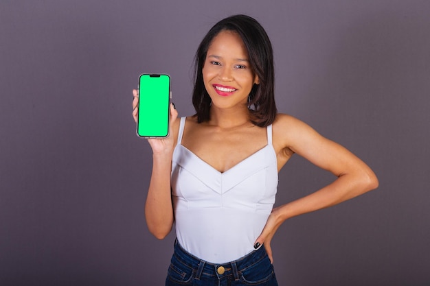 Young adult woman from northeastern brazil holding smartphone chroma key screen apps app technology