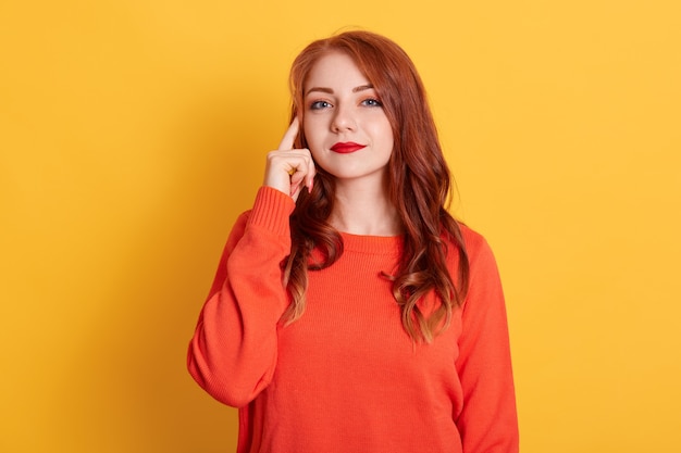 Young adult woman posing with pensive look, holding finger on temple