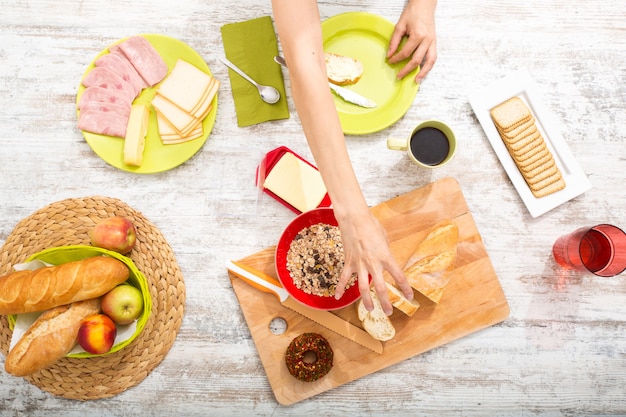 A young adult woman preparing a european style breakfast.
