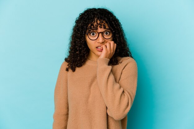 Young african american afro woman isolated biting fingernails, nervous and very anxious.