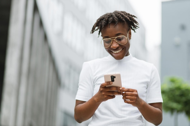 Young african american business lady in casual wear checking work emails outdoors