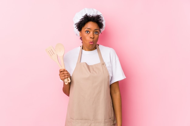 Young african american cook woman shrugs shoulders