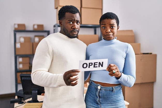 Young african american couple working at small business ecommerce skeptic and nervous, frowning upset because of problem. negative person.