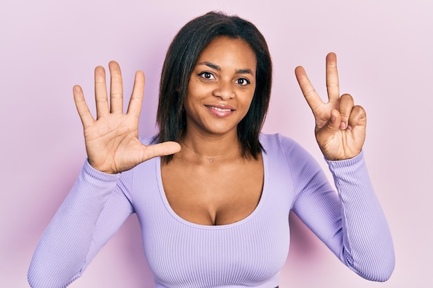 Young african american girl wearing casual clothes showing and pointing up with fingers number seven while smiling confident and happy