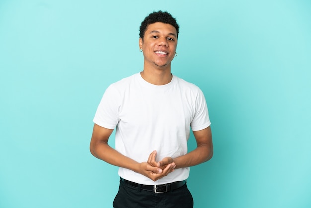 Young African American man isolated on blue background laughing