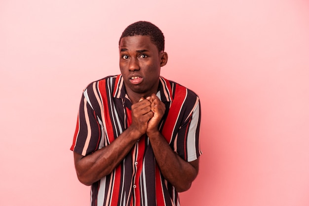 Young African American man isolated on pink background scared and afraid.